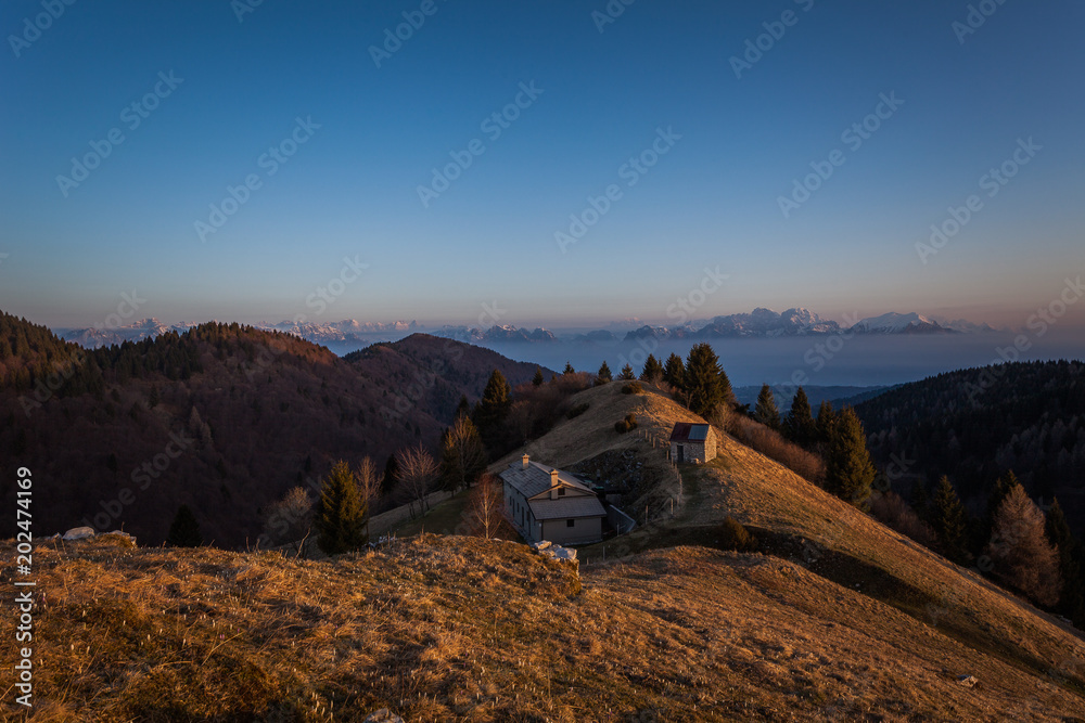 Sunrise on a small hut with in the background the dolomite peaks, Pian de le Femene, Veneto, Italy