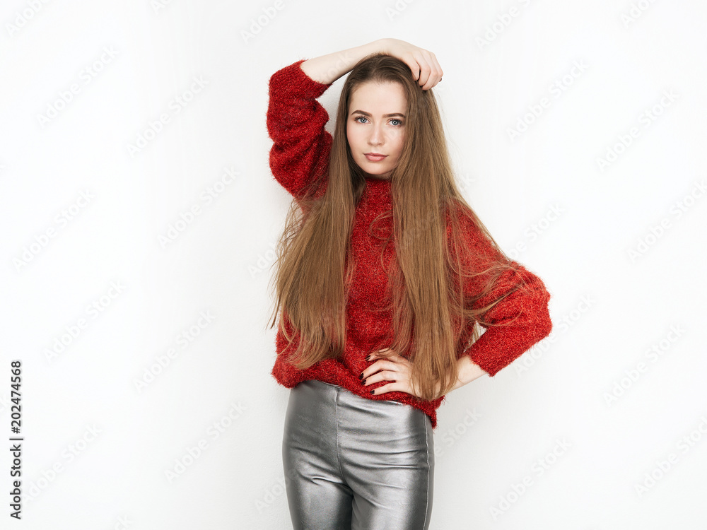 Spectacular blonde woman in red blouse silver leather pants posing in front of white wall. Graceful girl gorgeous long hair having fun on photoshoot. Spectacular blonde woman in red blouse silver leather pants posing in front of white wall. Graceful girl gorgeous long hair having fun on photoshoot.