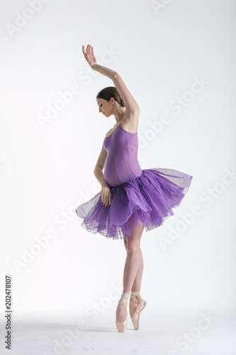 Young beautiful ballerina is posing in studio