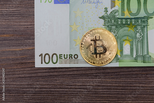 Gold Bitcoin coin with Euro banknote photo