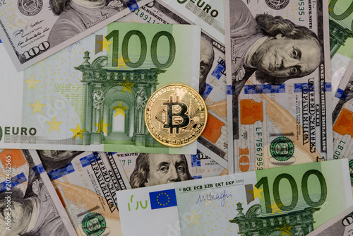 Gold Bitcoin coin on Euro and Dollars banknotes background photo