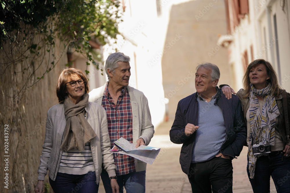 Φωτογραφία Group of senior friends walking in street of French town