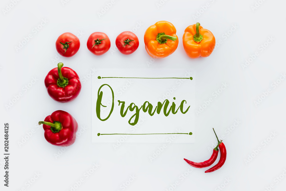 Φωτογραφία top view of frame of red and orange vegetables with word Organic isolated on whi