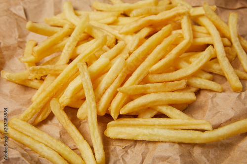 close-up shot of delicious french fries spilled over crumpled paper