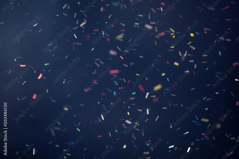Confetti fired on air during a festival at night. Image ideal for backgrounds. Multicolor are the confetti in the picture. The sky as background is black - obrazy, fototapety, plakaty 