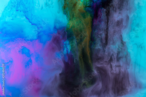 creative texture with purple and blue paint swirls in water