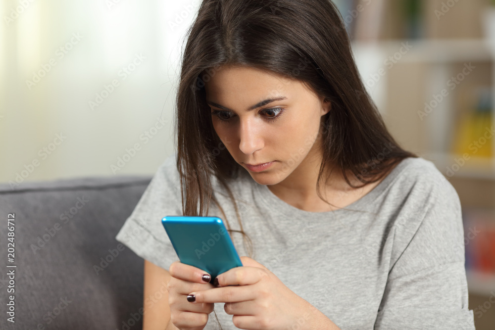 Fototapeta premium Girl texting obsessed with a smart phone
