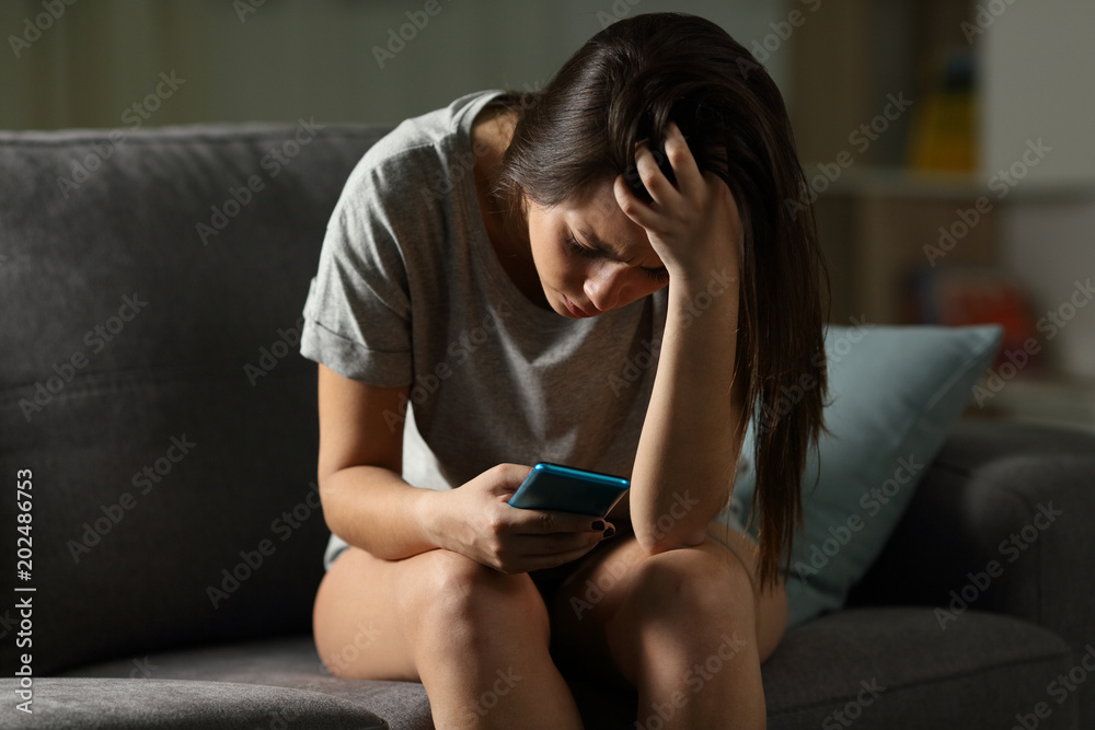 Φωτογραφία Sad teen being victim of cyber bullying online