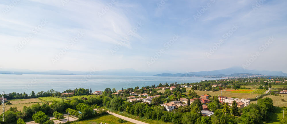 Garda Lake and high mountain in background. View from observation desk in GardaLand, Lombardy, Italy Garda Lake and high mountain in background. View from observation desk in GardaLand, Lombardy, Italy