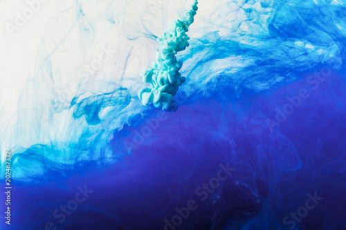abstract background with flowing blue and turquoise paint in water