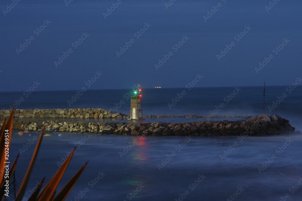 Faro de puerto deportivo por la noche con efecto agua de seda en el mediterráneo,Málaga,Andalucía,España. Faro de puerto deportivo por la noche con efecto agua de seda en el mediterráneo,Málaga,Andalucía,España.