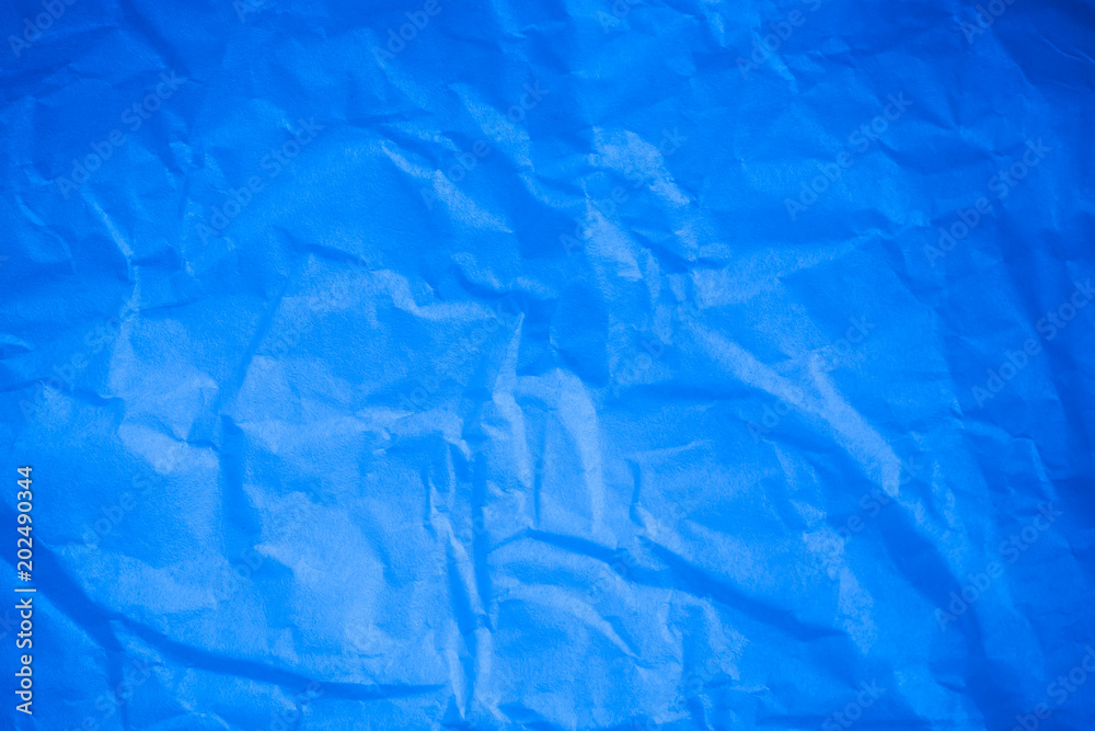 Obraz premium Crumpled blue paper background.