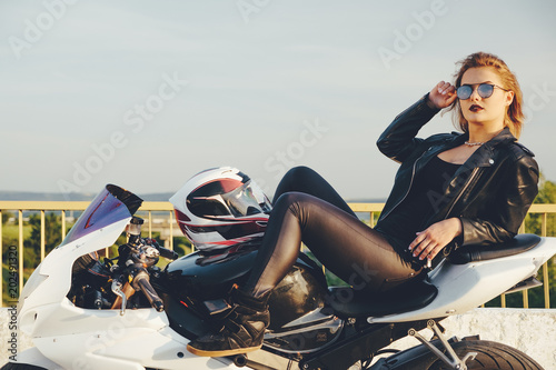 Beautiful woman biker laying on a bike relaxing