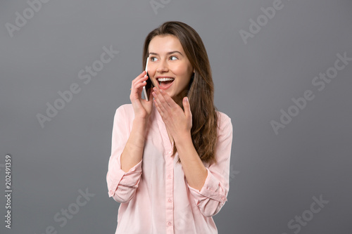 Pleasant interaction. Happy young woman laughing while talking to her friend on the phone