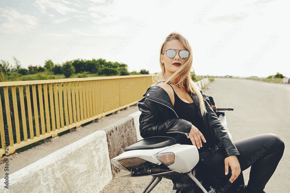 Beautiful woman posing with sunglasses on a motorbike Beautiful woman posing with sunglasses on a motorbike