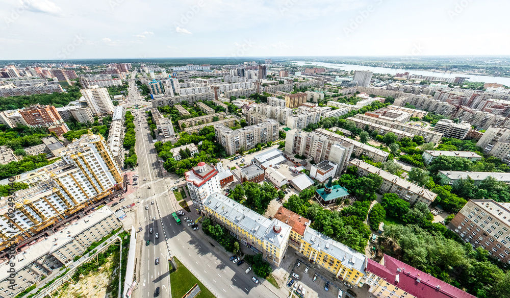 Aerial city view with crossroads and roads, houses, buildings, parks and parking lots, bridges. Helicopter drone shot. Wide Panoramic image.