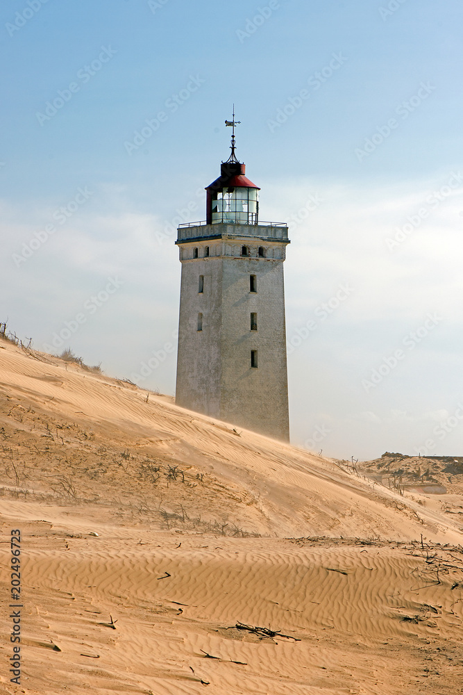 Lighthouse is disappearing in a wandering dune