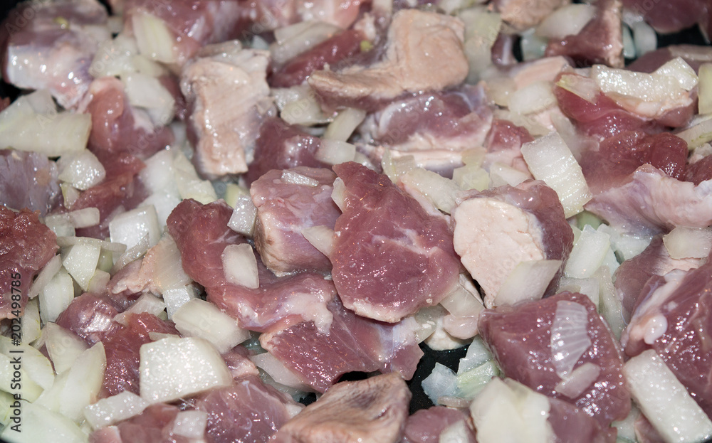 Raw chopped meat and and onion frying for goulash, cooking background Raw chopped meat and and onion frying for goulash, cooking background