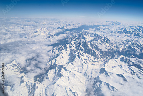 Aerial view of the Alps with snow and blue sky