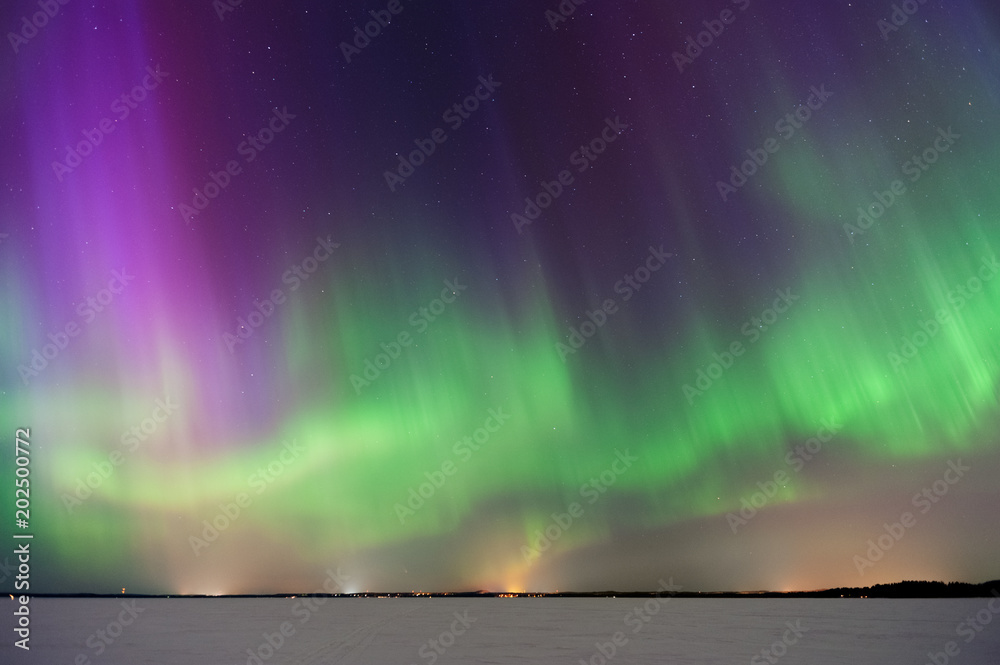 Aurora Borealis, Northern Lights, above frozen lake in Finland.