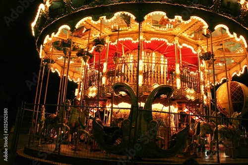 Night fun in Paris street, merry-go-round in the lights attracting tourists with fantasy