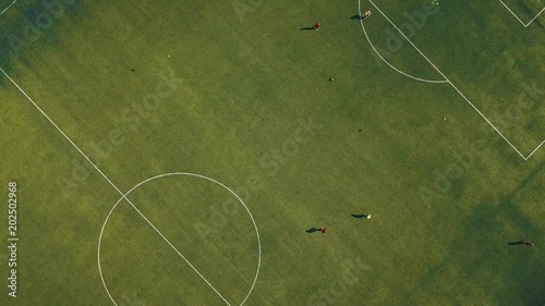 Aerial view of football team practicing at day on soccer field in top view photo