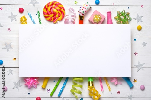 Birthday party caps, blowers, gifts, colorful balloons, serpentine and confetti on white background. Top view. Space for text.