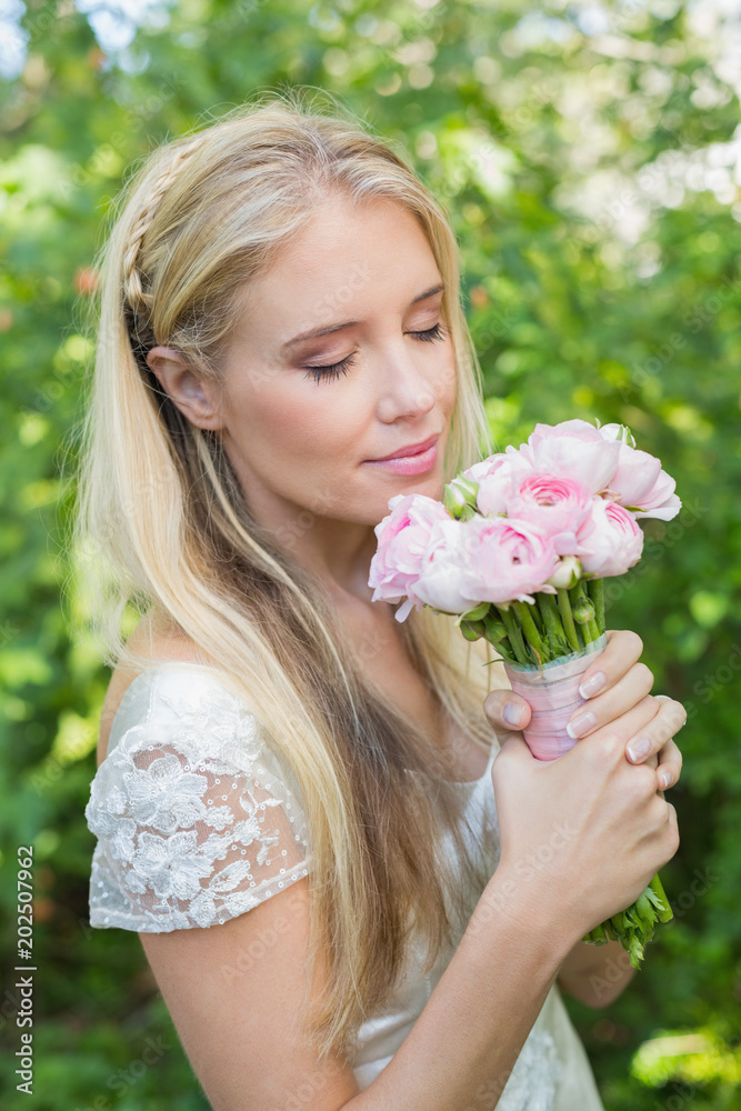 Blonde bride smelling her bouquet Blonde bride smelling her bouquet