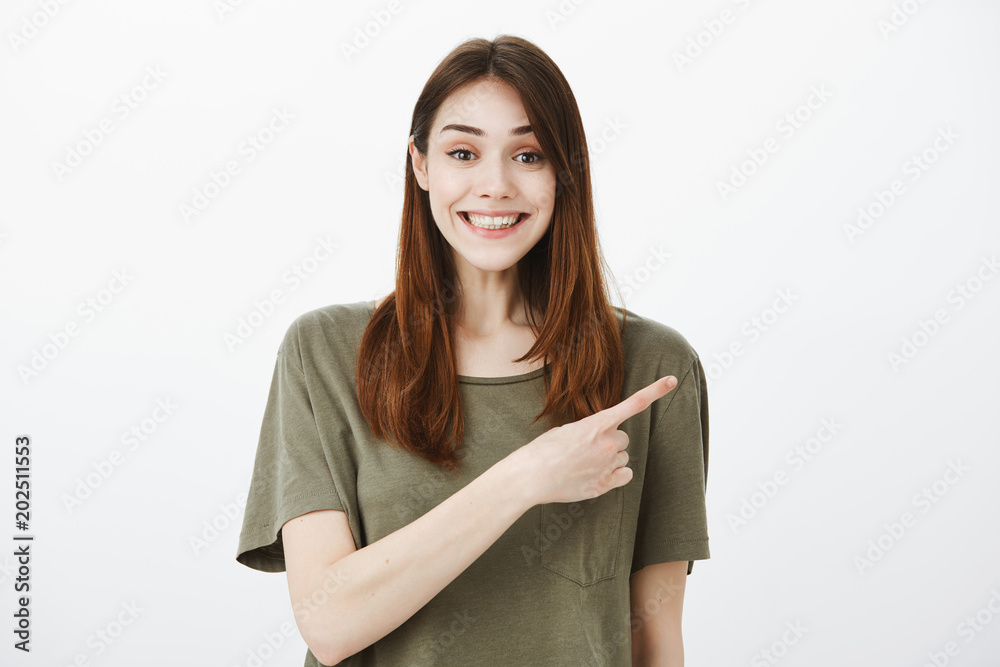 Girl cannot stand calm, being happy and excited, seeing awesome actor. Happy grinning attractive female student in casual outfit, smiling broadly from satisfaction, pointing at upper right corner Girl cannot stand calm, being happy and excited, seeing awesome actor. Happy grinning attractive female student in casual outfit, smiling broadly from satisfaction, pointing at upper right corner