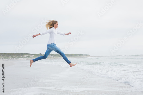 Side view of a casual woman jumping at beach