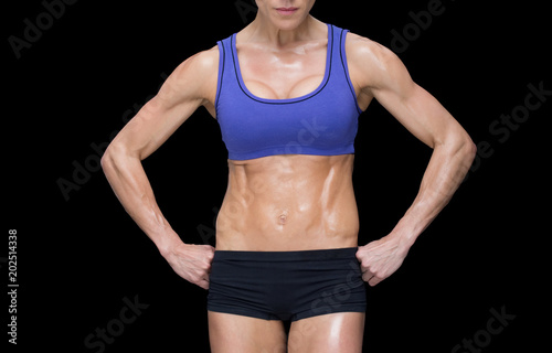 Strong woman posing in sports bra and shorts