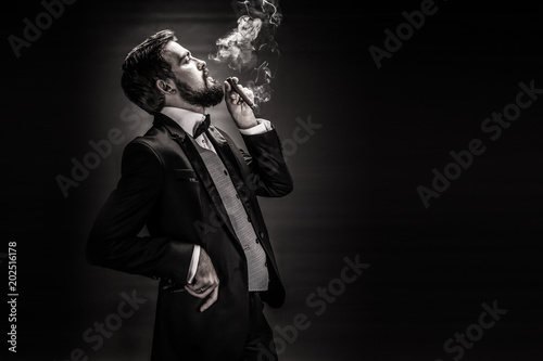 portrait of bearded smoking cigar gentleman in a suit photo