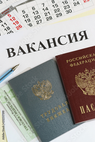 Russian documents for employment: employment record book, passport and insurance certificate. The inscription in Russian Vacancy