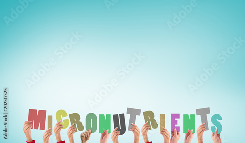 Hands holding up micronutrients against blue vignette background photo