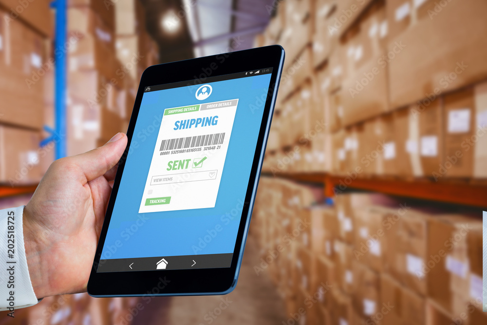 Fotografia Man using tablet pc  against shelves with boxes in warehouse
