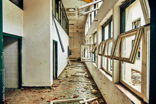 Destroyed and lowered interior of the building with broken windows with debris and glass shards on the floor