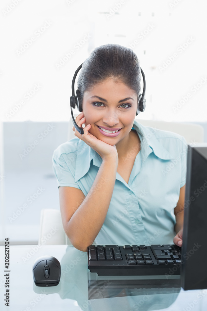 Businesswoman wearing headset while using computer Businesswoman wearing headset while using computer
