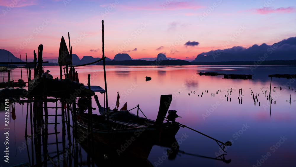 longtail boat with coastal fishing village ,Beautiful scenery morning sunrise over sea and mountain in phang - nga thailand