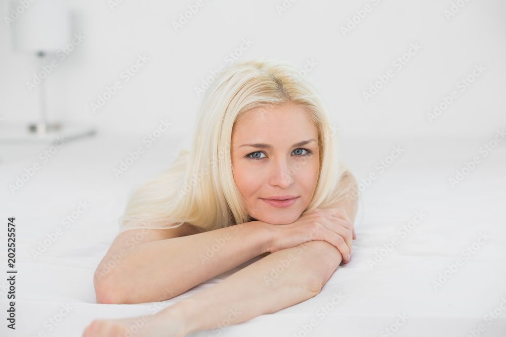 Portrait of smiling beautiful blond lying in bed Portrait of smiling beautiful blond lying in bed
