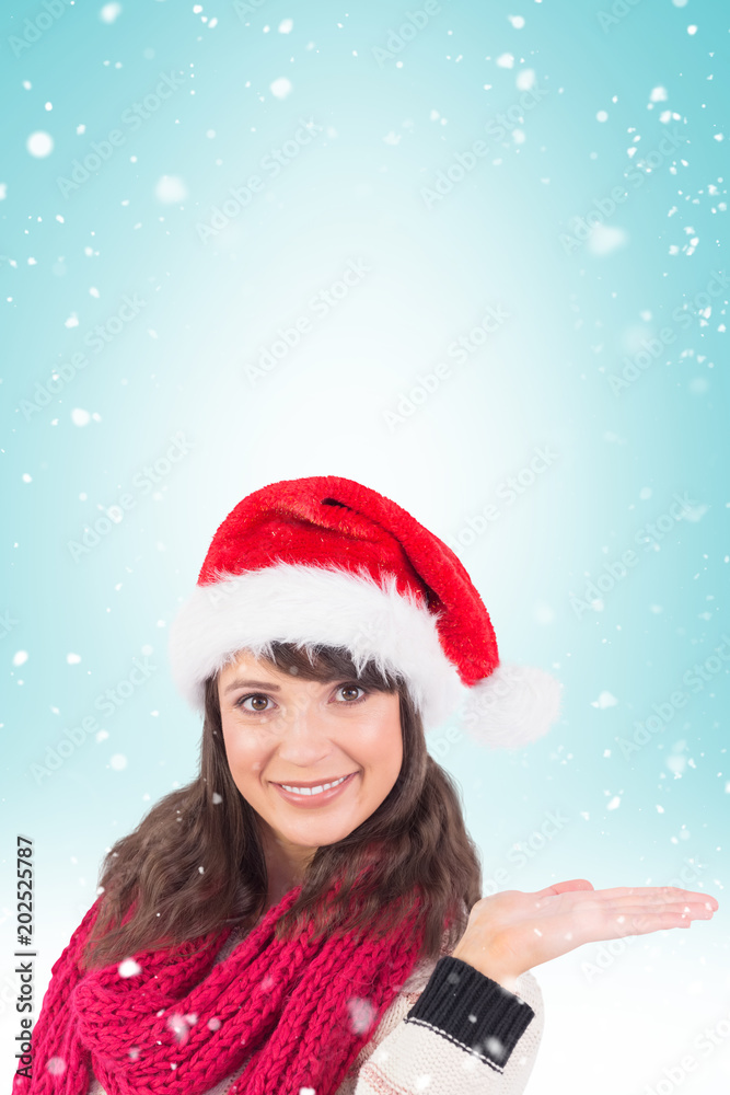 Festive young woman presenting with hand against blue vignette Festive young woman presenting with hand against blue vignette