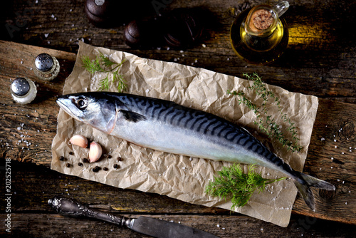 Fresh raw mackerel on an old wooden background.