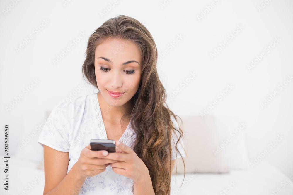 Content smiling brunette holding smartphone Content smiling brunette holding smartphone