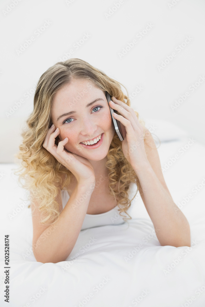 Pretty happy blonde lying on bed phoning Pretty happy blonde lying on bed phoning