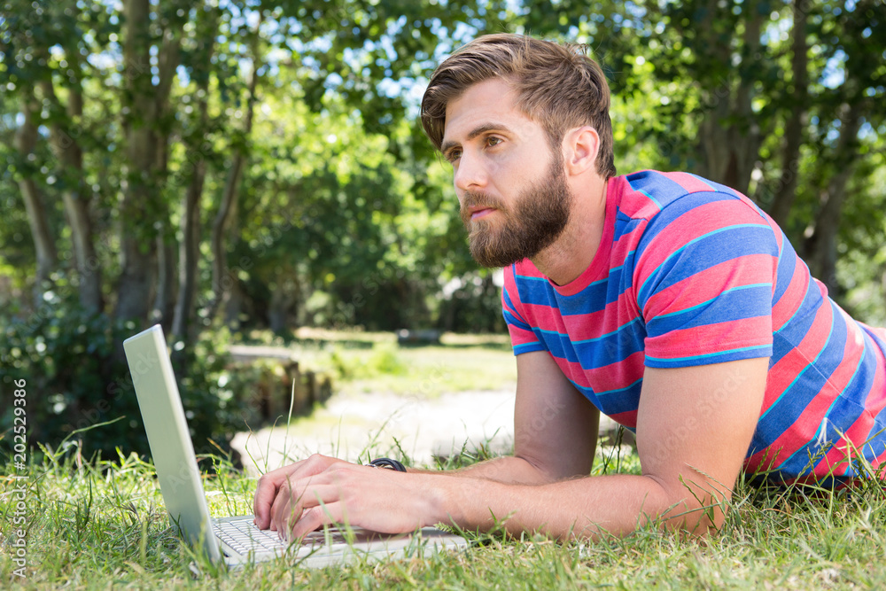 Hipster using laptop in the park Hipster using laptop in the park