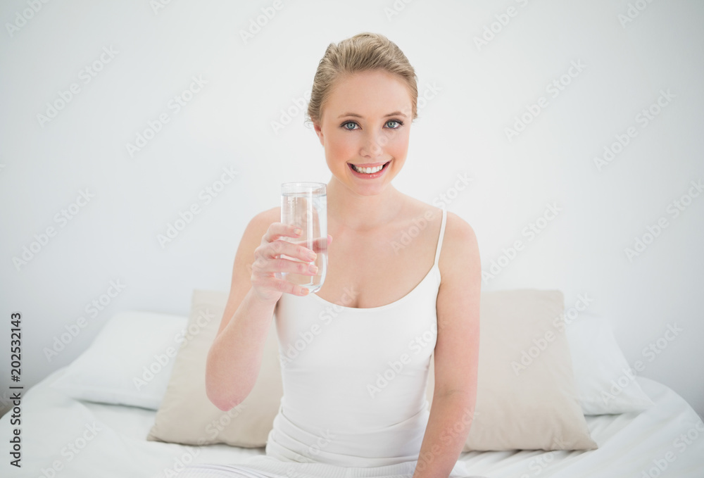 Natural smiling blonde holding glass of water Natural smiling blonde holding glass of water