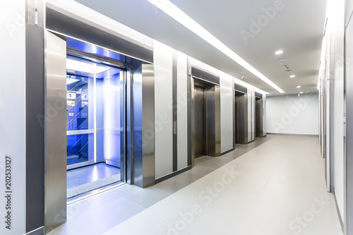 Modern steel elevator doors opened cabins in a business lobby or Hotel, Store, interior, office,perspective wide angle. Four elevators in hotel lobby.