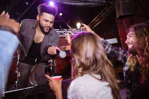 Male singer holding mic by female fan during performance