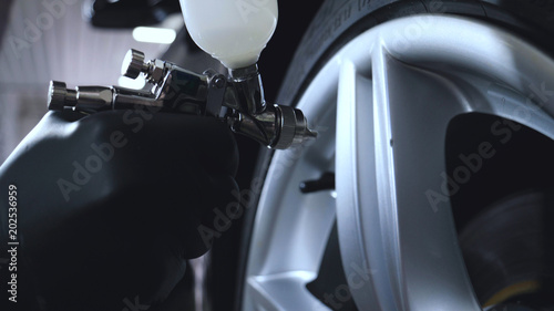 Professional coating of ceramic wheels and rubber, spray gun for painting, car service, shop, washing.