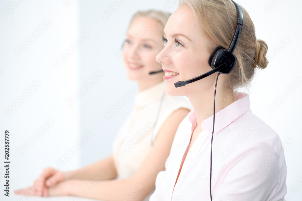 Naklejka premium Image of bright call center. Focus on young beautiful woman in a headset