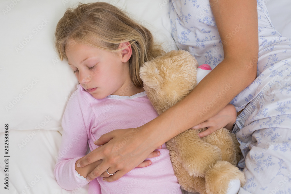 Girl and mother sleeping peacefully with stuffed toy in bed Girl and mother sleeping peacefully with stuffed toy in bed